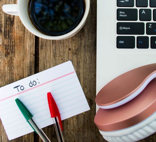 A top view shot of list what to do with pencils, laptop, headphones and a cup of coffee