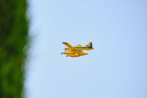 A yellow hydroplane flying in clear blue skies