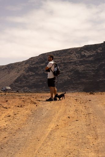 A selective focus shot of a Caucasian male  travelling with his dog
