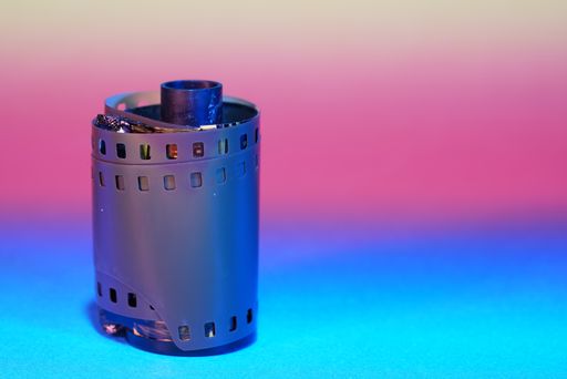 A closeup shot of a film from an old SLR camera on a colorful blurry background