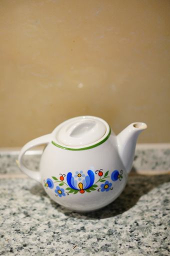 A vertical  shot of a ceramic teapot