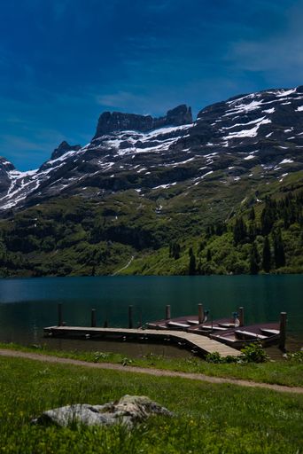 A wooden small bridge in the lake with the mountain background