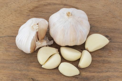A high angle shot of garlic on a wooden surface