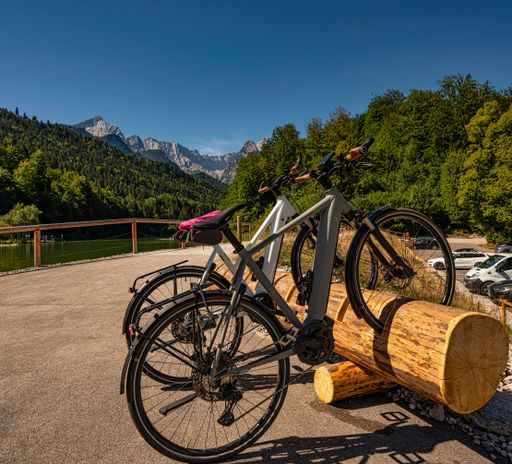 A closeup shot of two bikes in a wooden log rack in a national park in the Alps in southern Germany