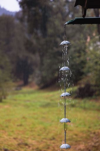A vertical closeup of a rain chain with umbrellas against the autumn park