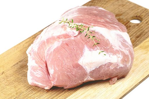 A closeup shot of a raw cut of meat on a wooden cutting board, ready to be cooked and served