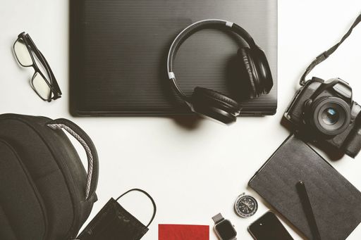 A top-down view of a work space, with a laptop and headphones on a table