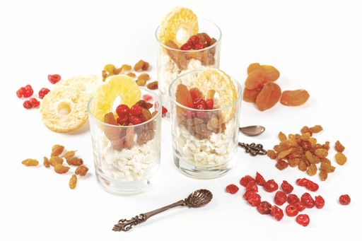 Three glasses with cottage cheese and dried fruits on a white background - the healthy breakfast concept
