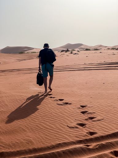 A man walking through the Arabian desert