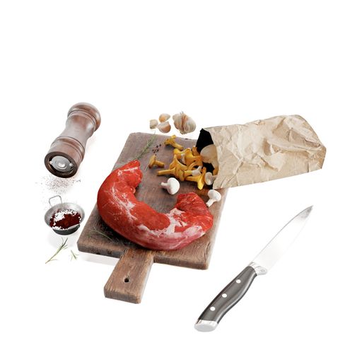 A closeup of a raw pork tenderloin with mushrooms on a wooden board next to utensils and garlic cloves