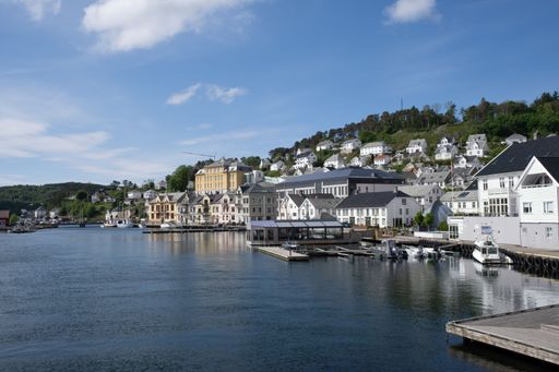 A beautiful view of Lyngdalsfjorden and town suburbs on a sunny spring day in Norway.