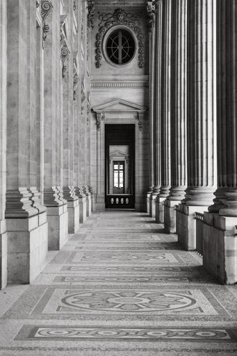 A vertical greyscale shot of the columns of Musee du Louvre, Paris, France