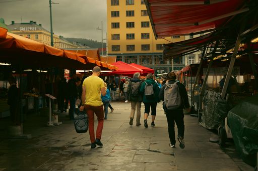 A busy street with people walking in a street market in Bergen
