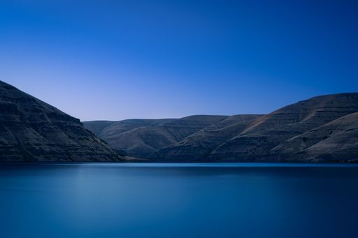 A long exposure of an idyllic scenery at Snake River with its blue water and hills in Washington, USA