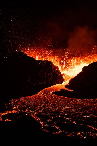 A vertical shot of lava flowing over rocky surface during 2022 Meradalir volcano eruption, Iceland