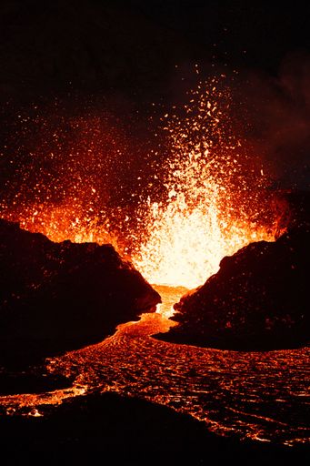 A vertical shot of lava flowing over rocky surface during 2022 Meradalir volcano eruption, Iceland
