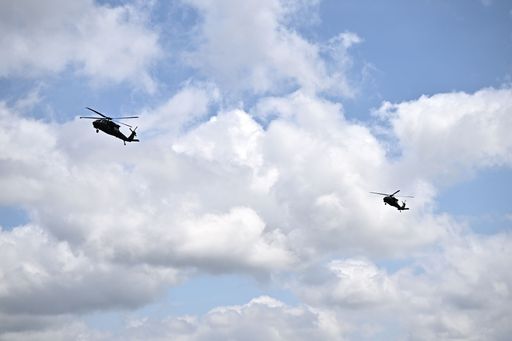 Two helicopters against a cloudy sky