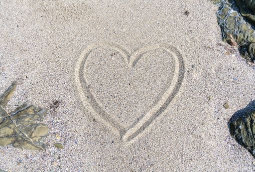 A heart drawn on sand of a beach