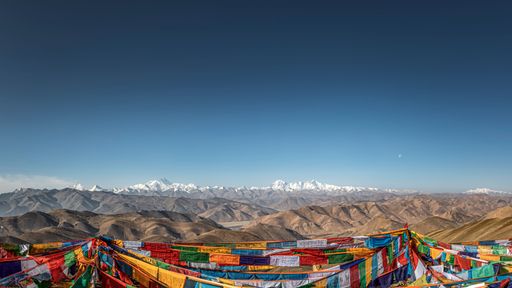 An aerial view snow covered Himalayan mountain landscape with flags