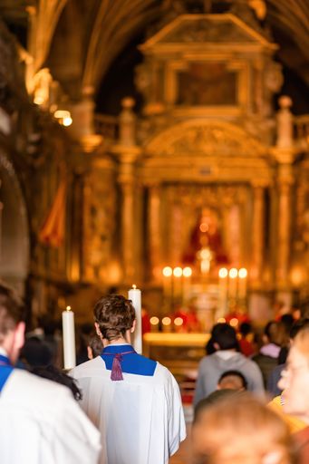 A vertical shot of people attending the congregation in a church