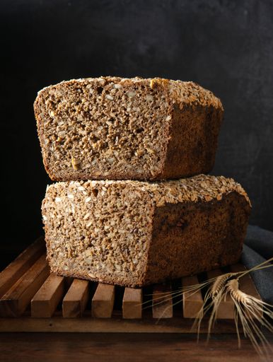 A vertical shot of cereal bread placed on a wooden surface