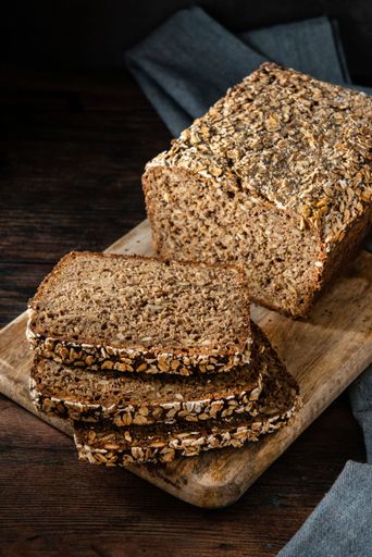 A closeup of a delicious Cereal bread on a wooden cutting board