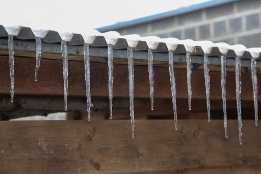 A closeup shot of icicles on the roof.