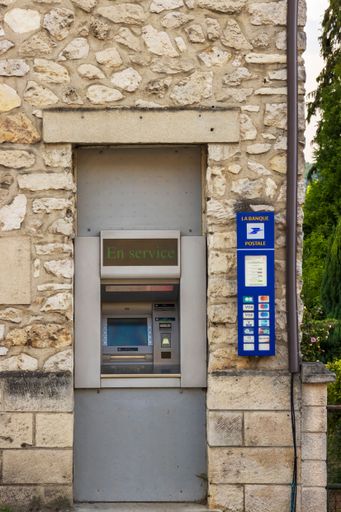 Vic-Sur-Aisne, France - Monday 25th July 2022: Cash machine, atm inset in a natural stone walled building. High quality photo