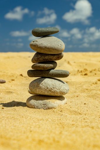 A closeup shot of the stones stacked on top of each other in the sand