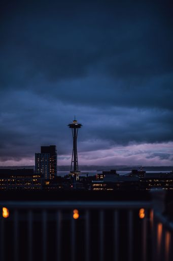 blue evening, dusk view of Seattle skyline from rooftop deck with string lights