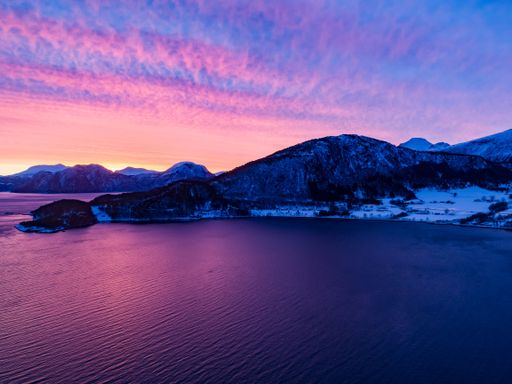 The beautiful view of the sea and mountains against the background of the purple sky at sunset. Norway.