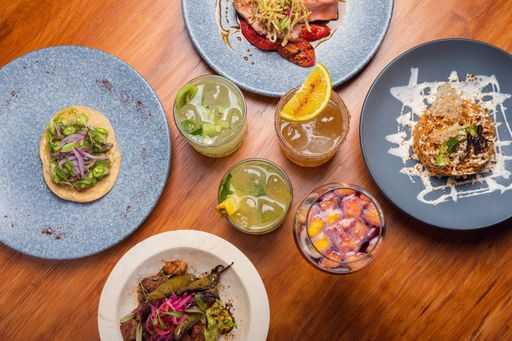 A flat lay of different kinds of cocktail drinks with different variations of food around