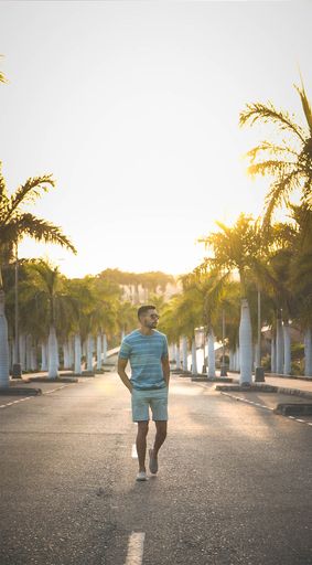 A vertical shot of a young man enjoying a summer walk at sunset.
