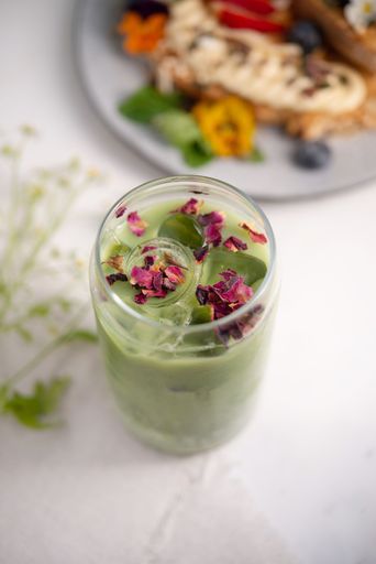 A top view of glass of green matcha latte on table
