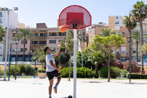 Young muslim man playing street basketball on a city court, training and sport concept, copy space