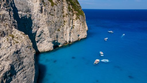 An aerial view of boats in the sea with a coast