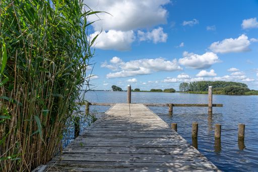 A beautiful shot of an old wooden jetty made of planks under a blue cloudy sky