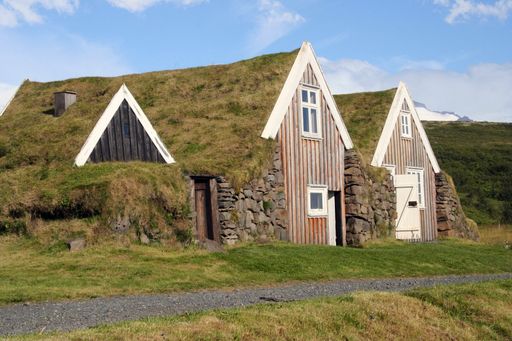 Historical old farmer house buildt in the grass hills in the backland of Iceland with blue sky on a summer day
