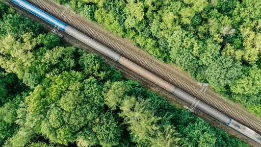Aerial view of a passenger train driving through a forest near Prague, Czech Republic