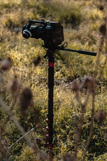 A vertical shot of a black camera on the grass