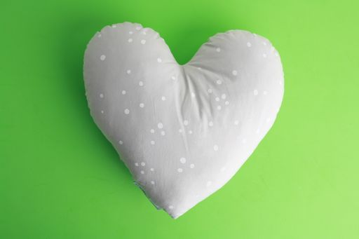 A closeup shot of a white pillow in a heart shape