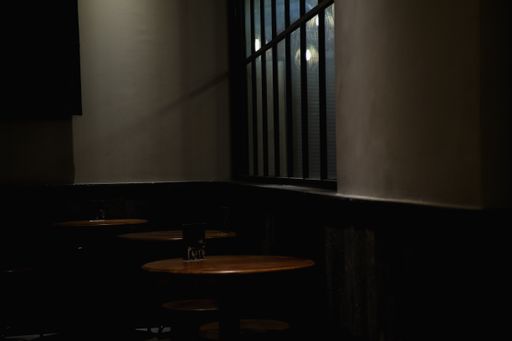 Empty tables under a window at a dark cafe