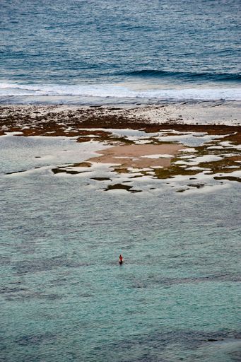 A Fisherman in the sea at low tide in Nusa Dua, Bali, Indonesia