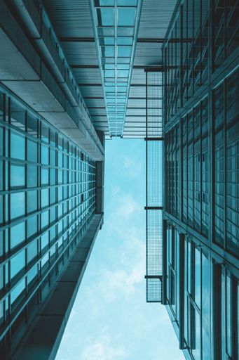 A low angle shot of a modern building against the blue cloudy sky