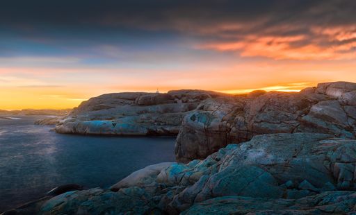 The rocky cliffs by thy calm sea with the beautiful sunset in the colorful sky in the background