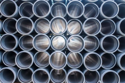 A stack of orange plastic sewage pipes used at the building site