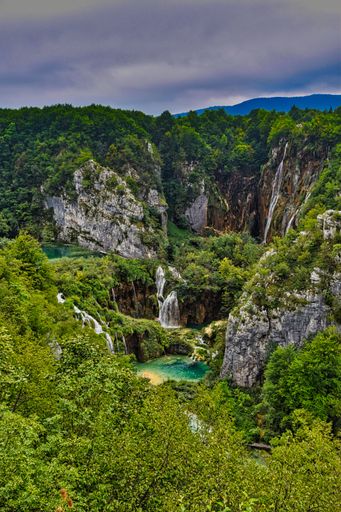 A vertical shot of the waterfalls in Plitvice, Croatia, under the cloudy sky