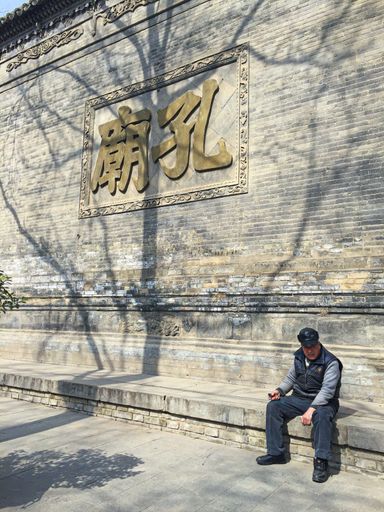 An old man sitting in front of the Confucian Temple 'Kong Miao' in Xi'an City, China