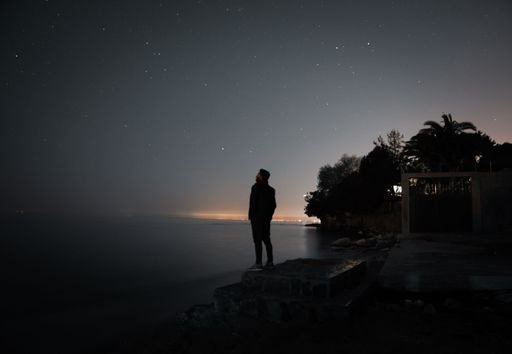 A silhouette of a man watching the starry night sky, a tranquil and magical scene