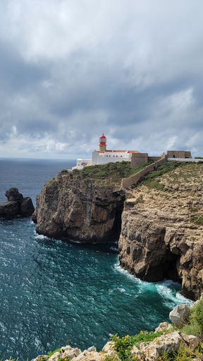 A vertical shot of Cabo de Sao Vicente lighthouse on the top of a cliff against the Atlantic